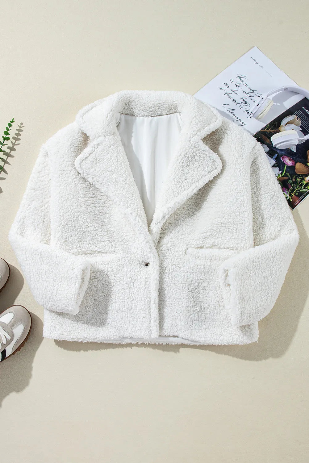 White teddy bear collarless jacket with lapels and a single clasp closure.