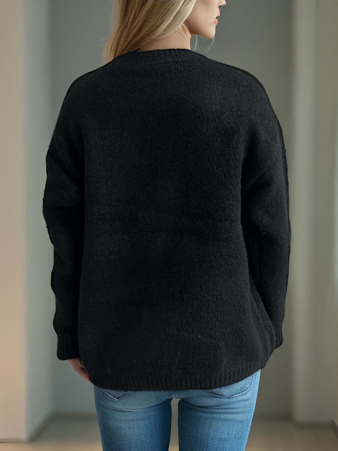 Black acrylic knit sweater with crew neck and long sleeves, showing back view.