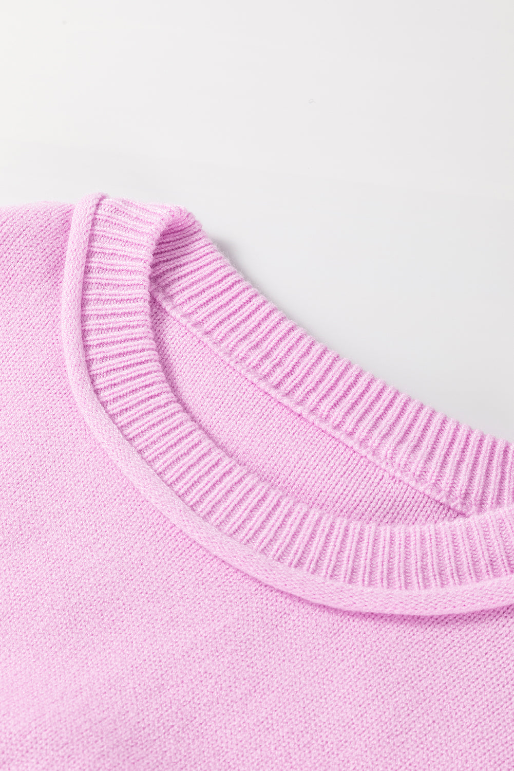 Pink knit sweater with contrast stitching detail on neckline and cuffs.