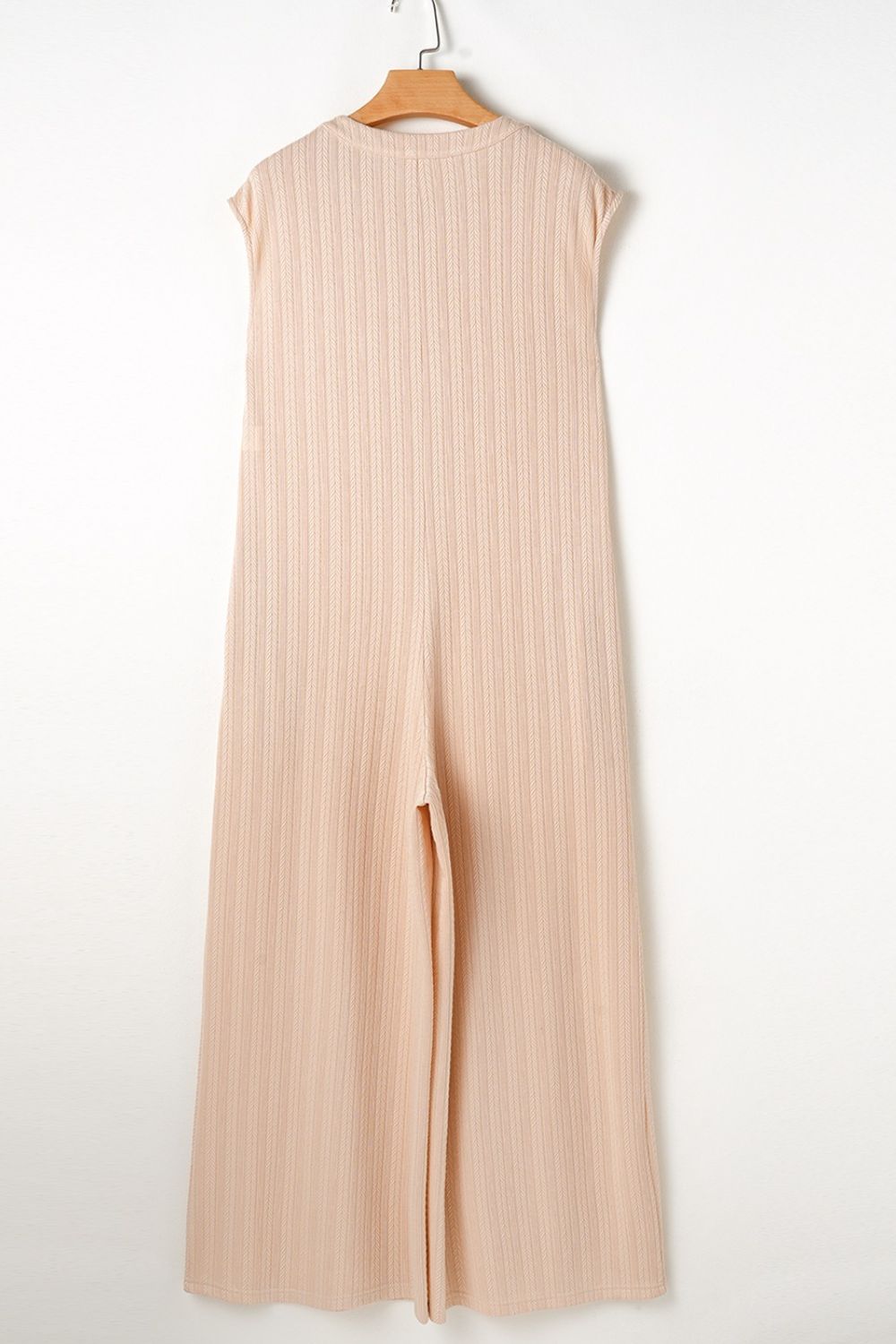 Textured ribbed sleeveless collar jumpsuit in eggshell with wide leg and side slit.