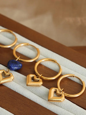 Gold geometric heart hoop earrings with a blue stone charm option.