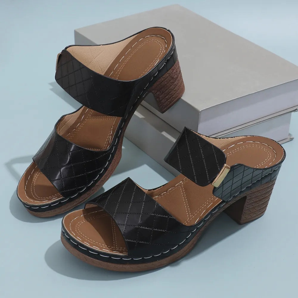 Black quilted leather platform mules with block heel and open toe.