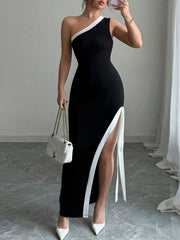 Black asymmetrical maxi dress with white trim and high slit, one-shoulder neckline, decorative ties.