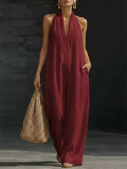 Burgundy halter neck wide-leg jumpsuit with deep V-neck and pockets.