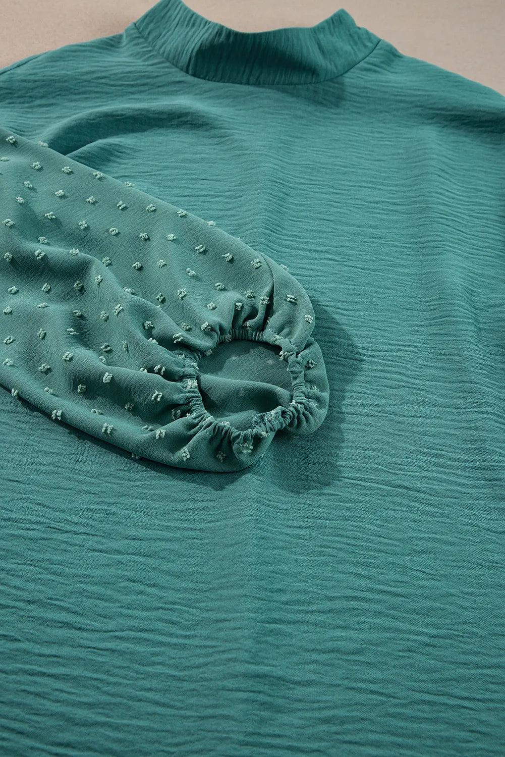 Teal textured blouson top with Swiss dot sleeves and mock neck