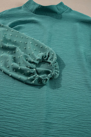 Teal textured blouson top with Swiss dot sleeves and mock neck
