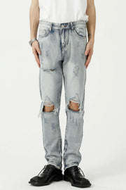 Light wash ripped knee slim fit denim jeans with distressed details.
