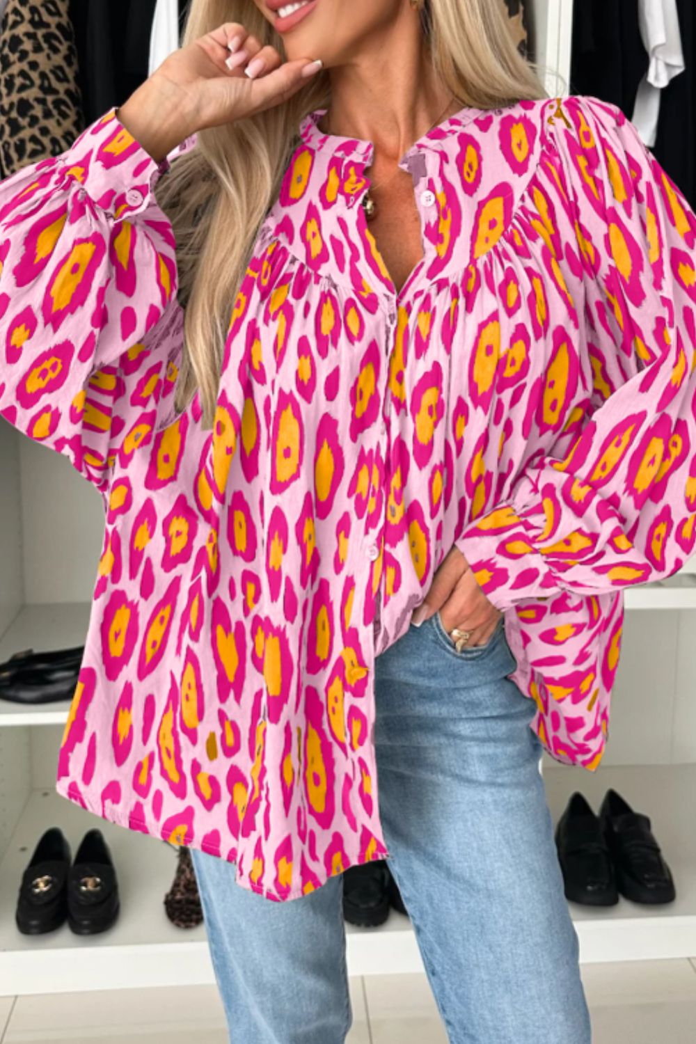 Pink leopard print balloon sleeve blouse with button front and ruffled collar.