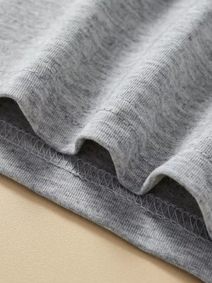 Grey cotton toddler top and shorts set detail showing stitching and fabric texture.