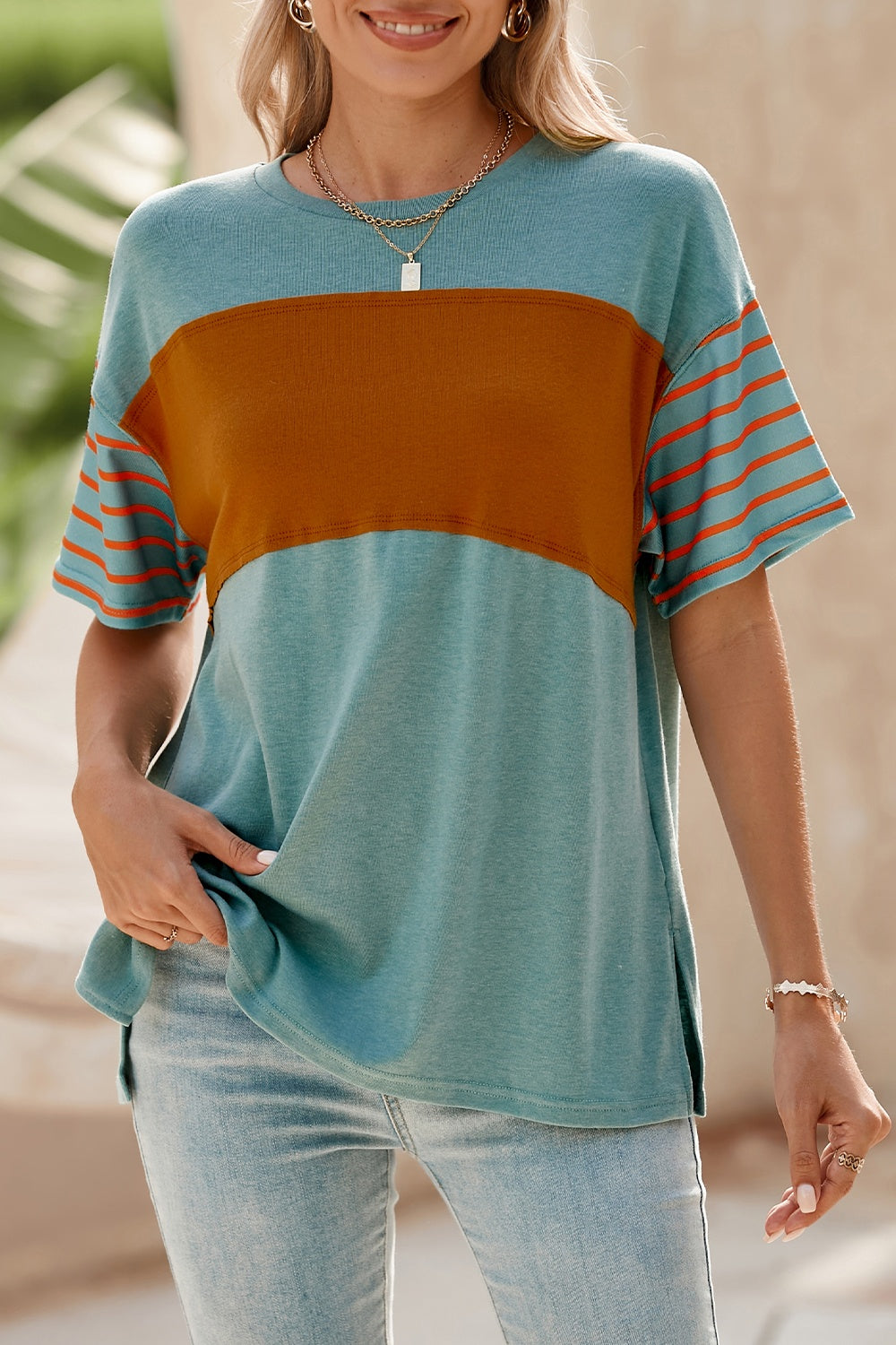 Colorblock raglan tee with side slits in turquoise and orange stripe sleeves, featuring a chocolate band.