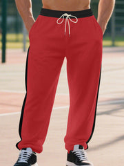 Men's bright red sweatpants with black side stripes and drawstring waist