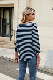 Striped long sleeve blouse with ruched cuffs and neckline, in navy and light blue stripes.
