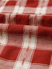 Smocked puff sleeve mini dress in red and white plaid cotton fabric with textured detail.