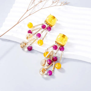 Beaded cascade statement earrings in yellow and magenta with gold accents.