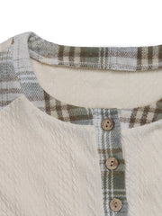 Textured cream raglan henley top with green plaid trim and wood buttons.