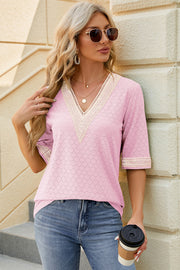 Blush pink textured v-neck top with lace trim and elbow sleeves.