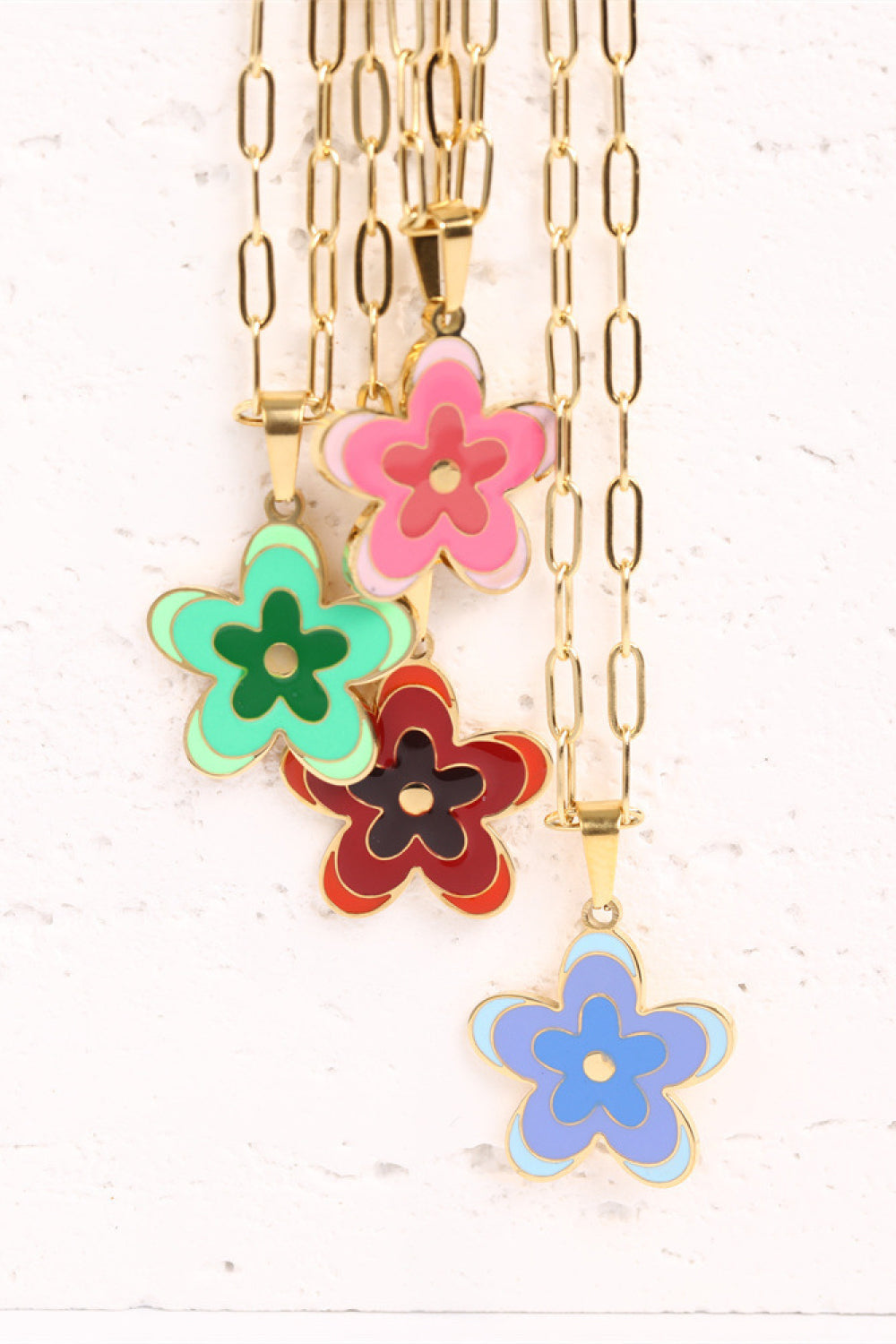Enamel floral pendant necklaces in red, green, pink, and blue on gold-plated chains.