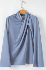 Dusty blue blouse with draped neckline and bell sleeves.