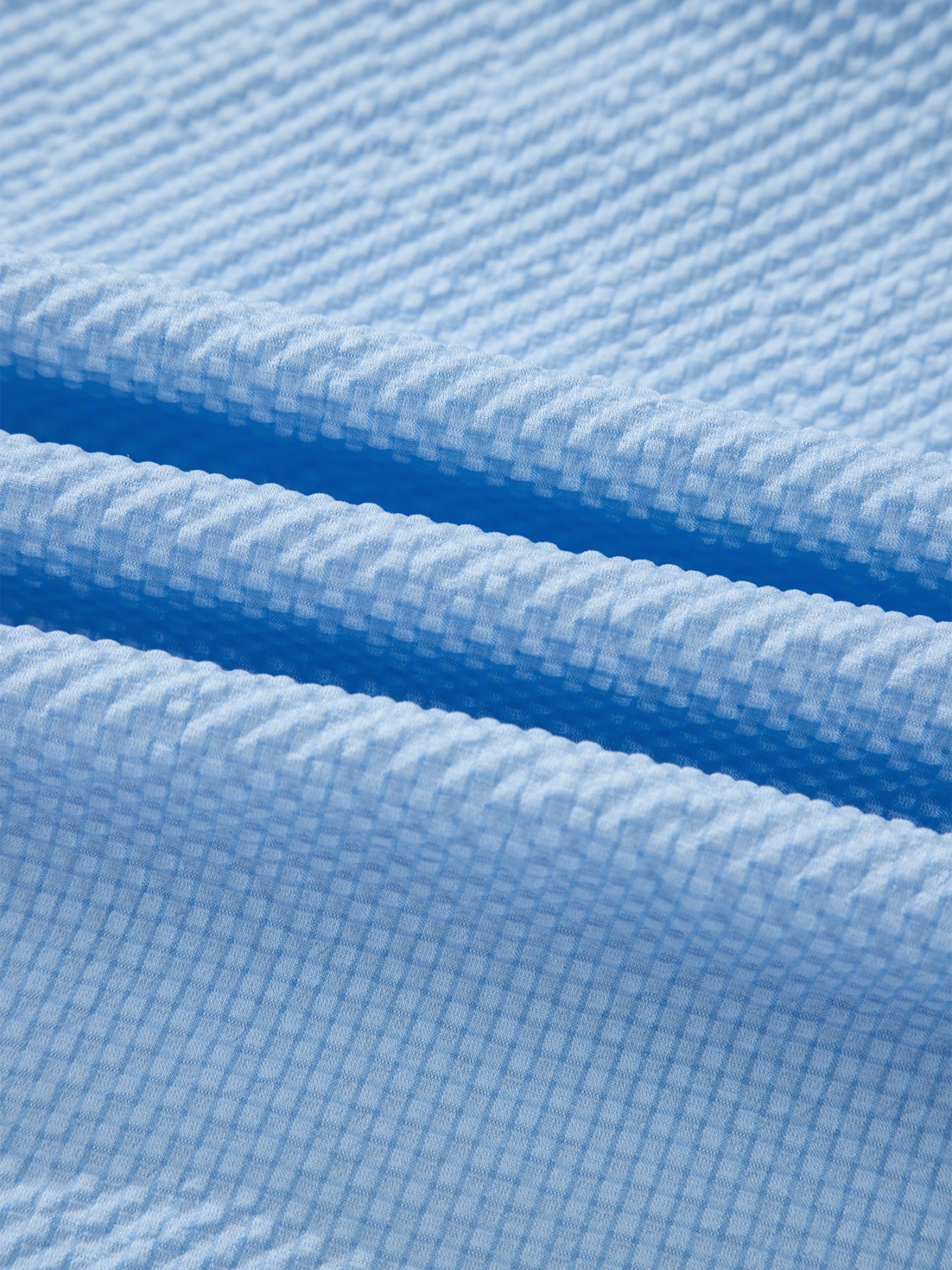 Light blue seersucker fabric detail on a relaxed fit blouse.