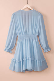 Sky blue ruffled mini dress with smocked waist and bell sleeves.