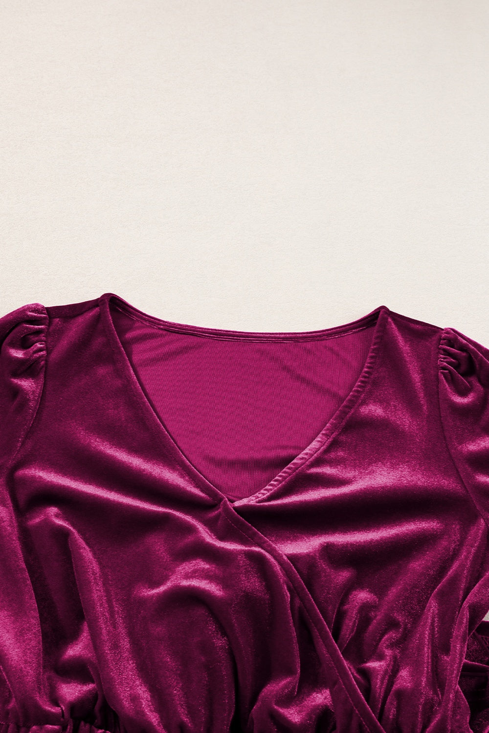 Burgundy velvet wrap romper with V-neck and ruffled cap sleeves.