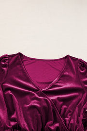 Burgundy velvet wrap romper with V-neck and ruffled cap sleeves.