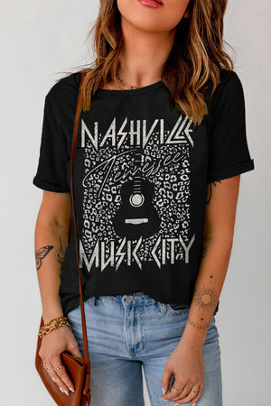 Black graphic tee with Nashville Music City print and guitar graphic on leopard pattern.