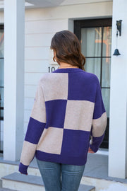 Checkerboard knit crewneck sweater in indigo and tan acrylic with long sleeves.