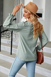 Sage textured puff sleeve blouse with ruffle cuffs and a diamond pattern.