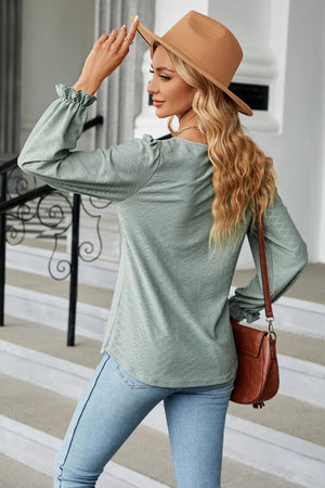 Sage textured puff sleeve blouse with ruffle cuffs and a diamond pattern.