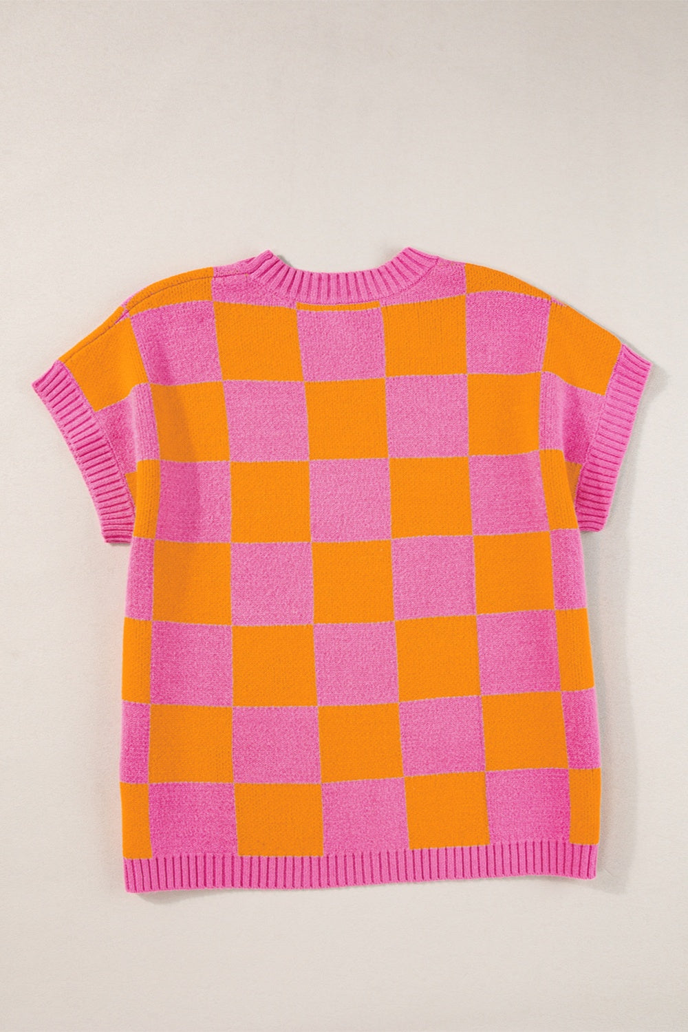 Checkerboard knit cap-sleeve top in pink and orange plaid with a crew neck.