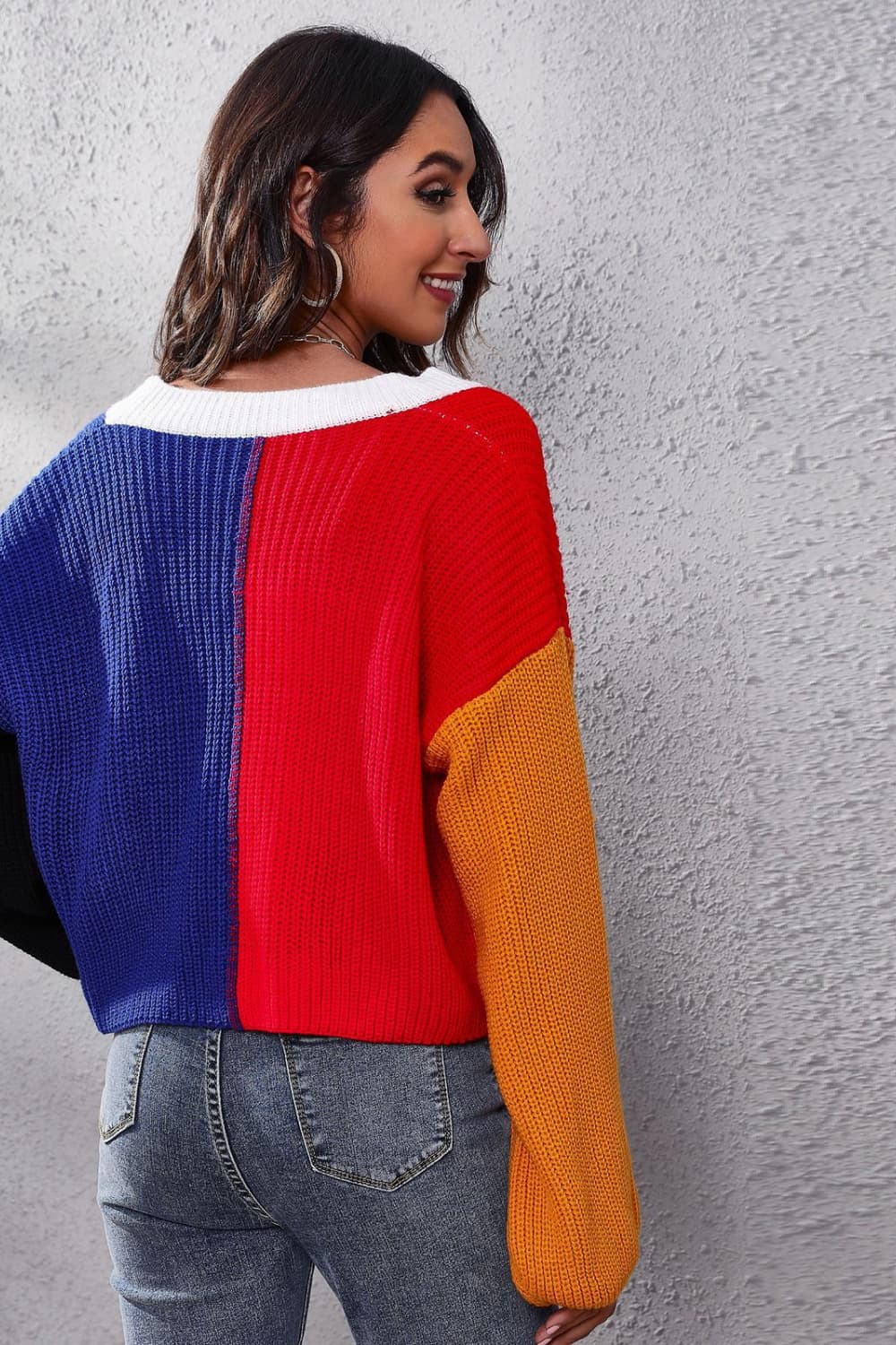 Panelled ribbed knit cardigan in red, blue, and orange with a white neckline.