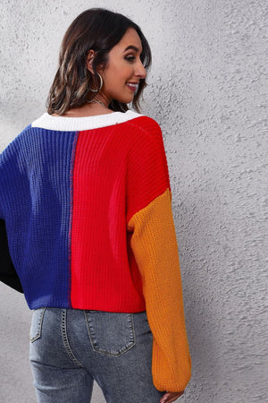 Panelled ribbed knit cardigan in red, blue, and orange with a white neckline.