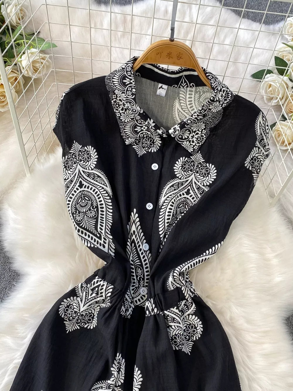 Black buttoned romper with white paisley print, collared, short sleeves