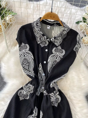 Black buttoned romper with white paisley print, collared, short sleeves