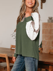 Dark green waffle knit henley top with white lace sleeves and leopard print detail.