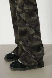 Camo flare denim trousers in green camouflage pattern.