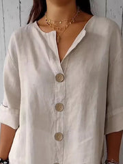 Beige button-down shirt with relaxed fit, collarless neckline, and wooden buttons.