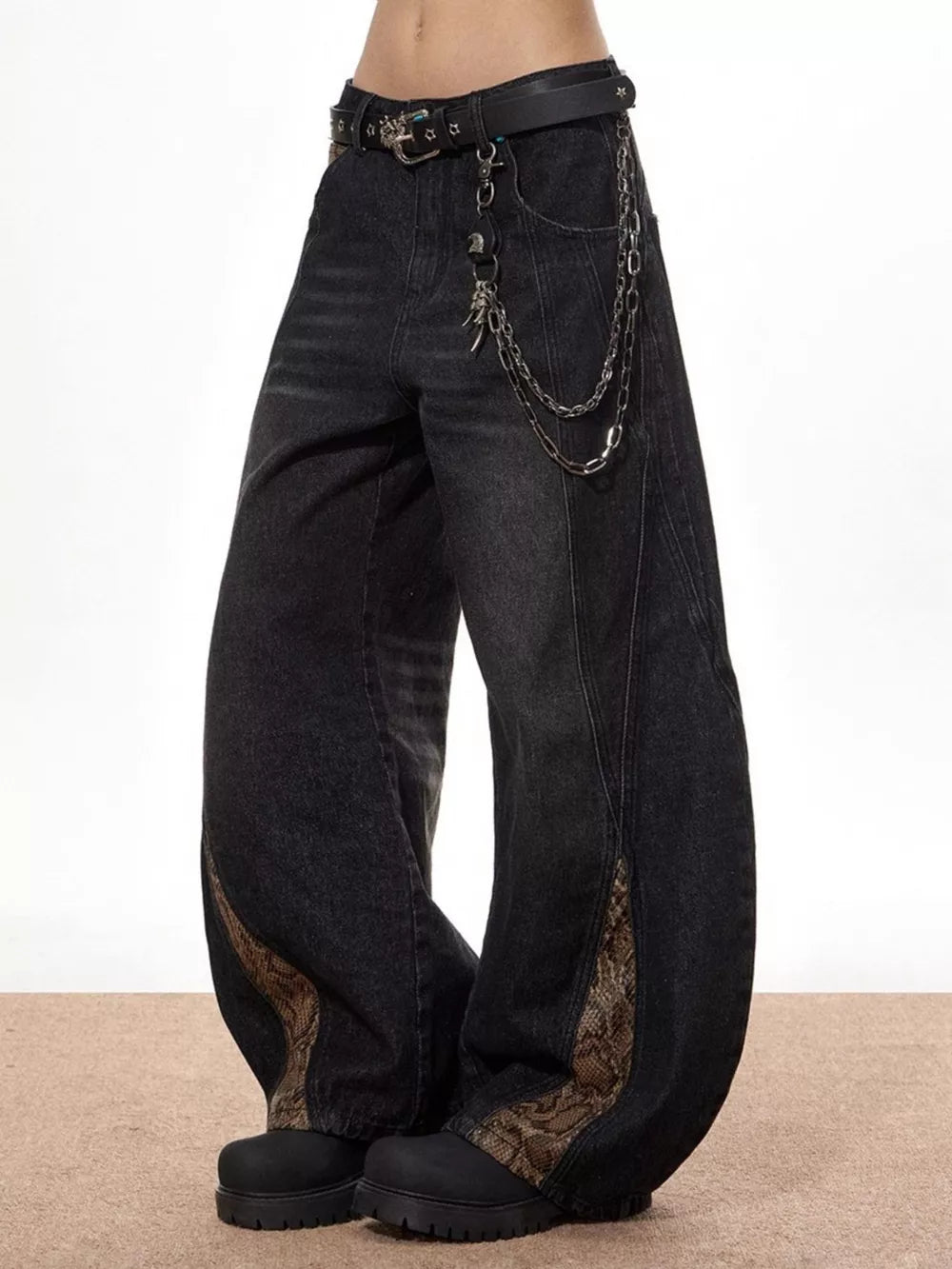 Vintage wide leg jeans in black denim with snake print accents and chain detail.