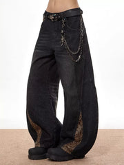 Vintage wide leg jeans in black denim with snake print accents and chain detail.