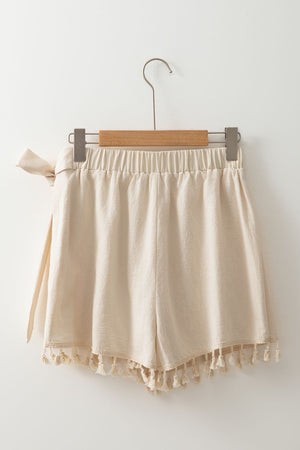 Beige cotton wrap skort with tassel trim and tie waist detail.