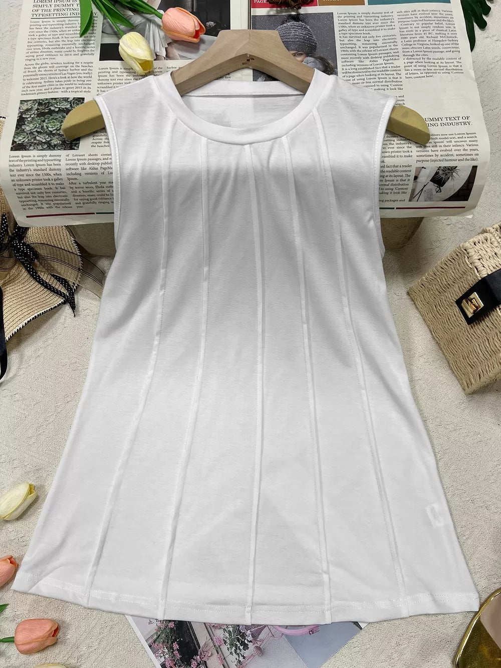 White sleeveless tank top with vertical pleat detailing and a crew neck.