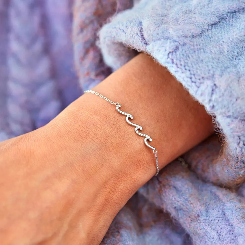 Silver wave zirconia bracelet with adjustable chain detail.