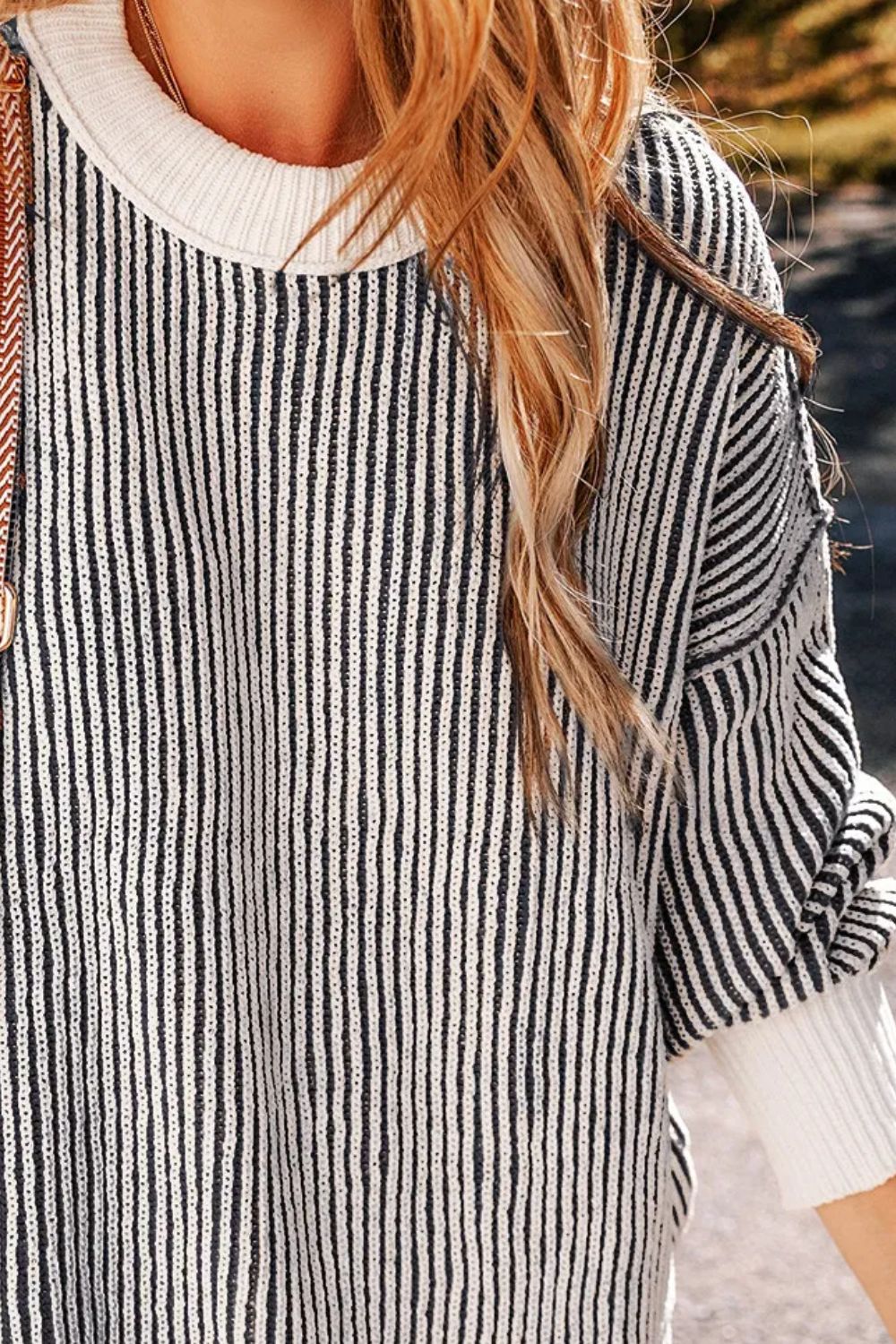 Black and white striped drop-shoulder knit sweater with crew neck and cuffed sleeves.