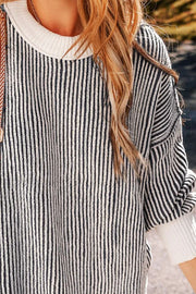 Black and white striped drop-shoulder knit sweater with crew neck and cuffed sleeves.