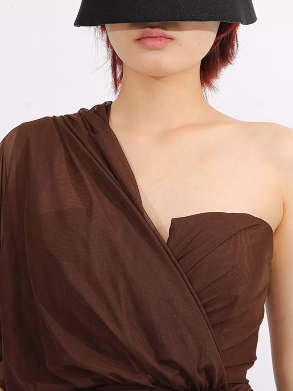 Brown draped one-shoulder maxi dress with sheer fabric and ruched bodice detail.