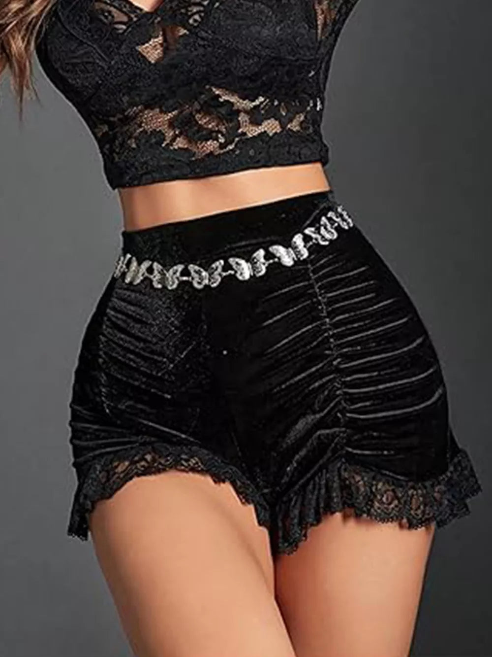 Black velvet shorts with lace trim and ruched sides, featuring a decorative butterfly belt.