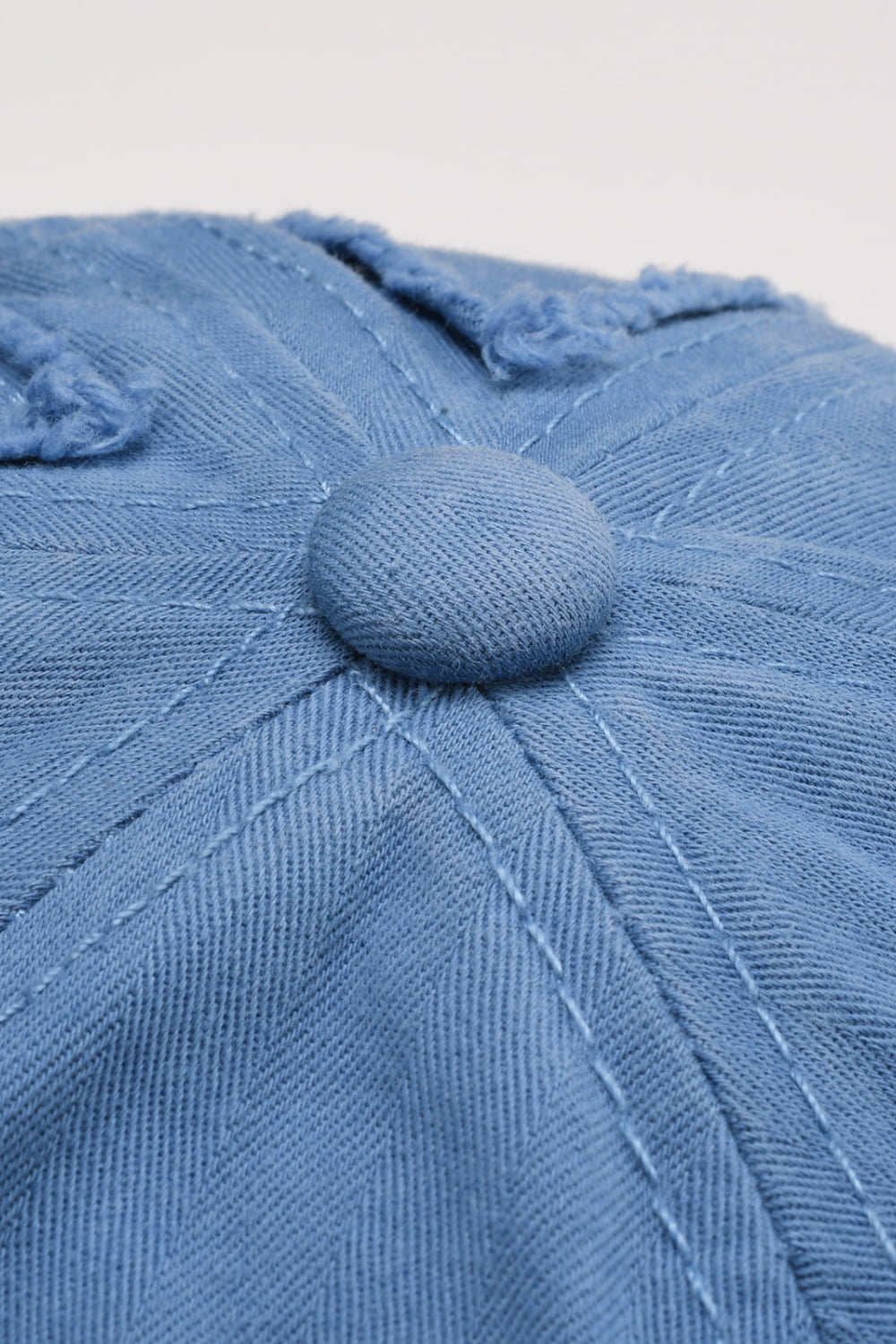 Cobalt blue denim baseball cap with raw edge detail and button top