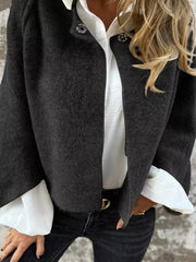 Black fuzzy knit cardigan with button detail, open front, worn over white shirt.