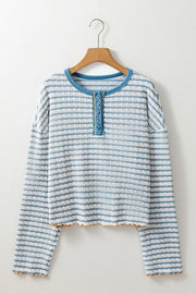Textured stripe henley sweater in dusty blue with button placket and lettuce hem detail.